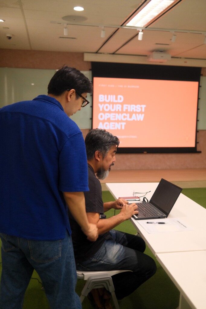 A mentor guiding a builder through their first agent setup at Workshop #04